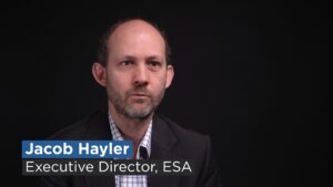 ESA Executive Director Jacob Hayler against a black backdrop with title