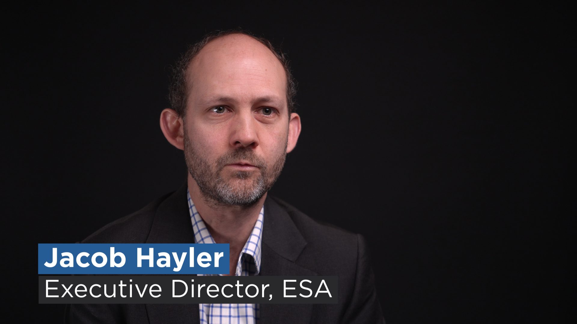 ESA Executive Director Jacob Hayler against a black backdrop with title