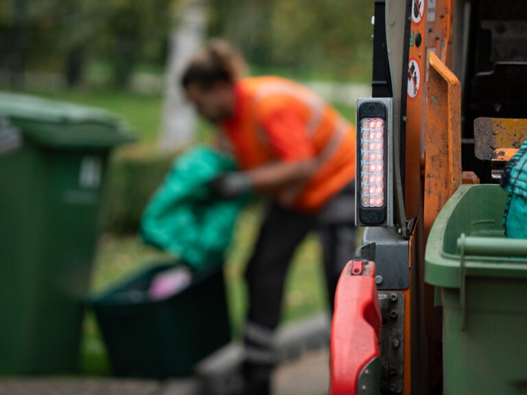 Operative in orange high-vis collects recycling at the kerbside
